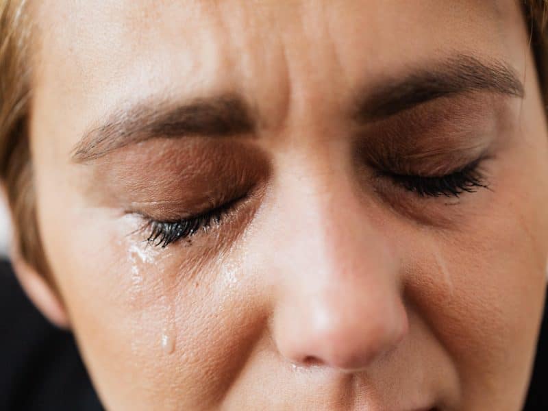 tears on face of crop anonymous woman