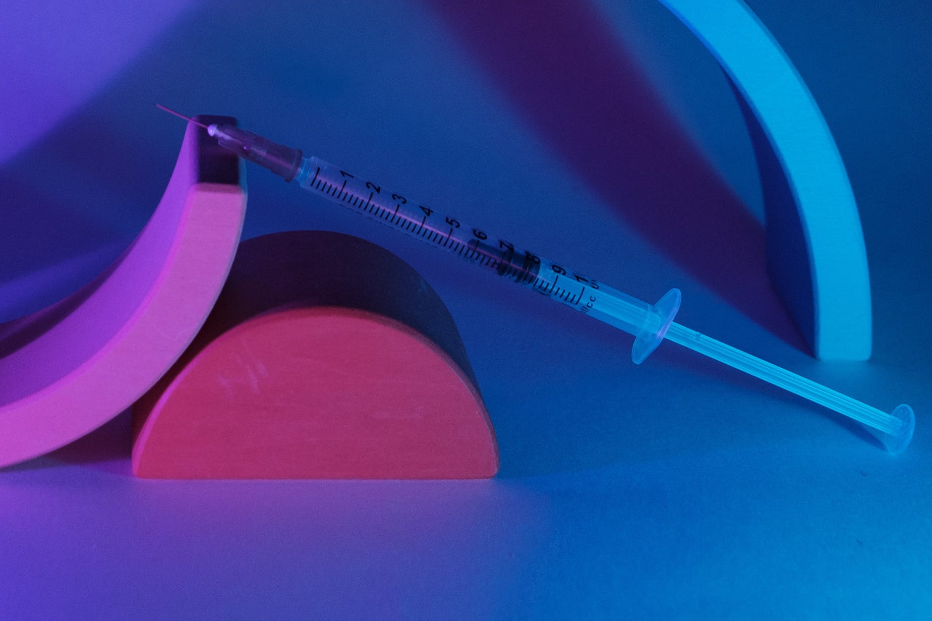 medical syringe on geometrical figures in ultraviolet light