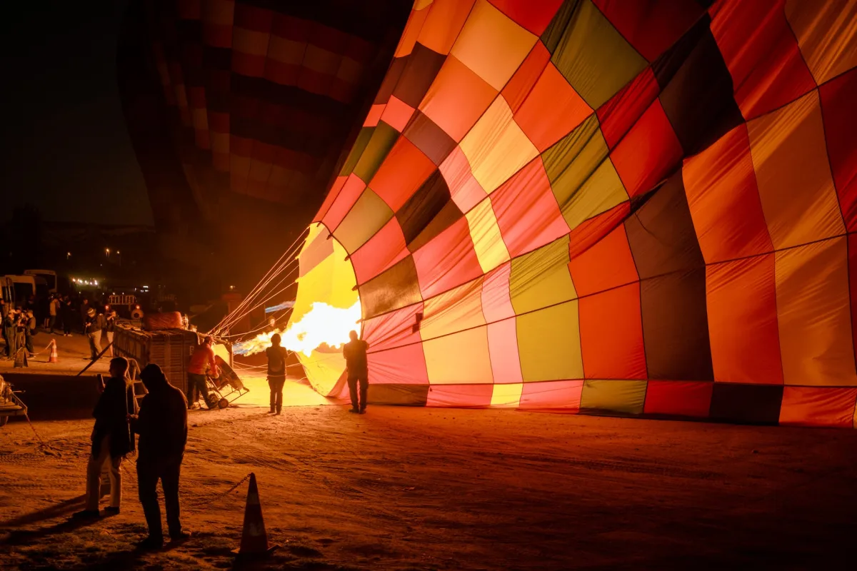 people standing near hot air balloons