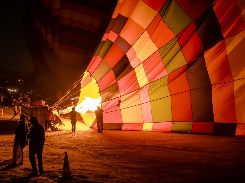 people standing near hot air balloons